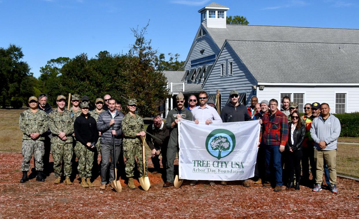 Whiting Field team members stand in front of the 2-year-old juvenile live oak planted onboard the installation. The base has participated in Tree City USA for 31 consecutive years to preserve and enhance its natural environment.