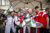 <p>England fans pose for a photo with a Russian fan, right, at a bar in Red Square – complete with inflatable Spitfires. </p>