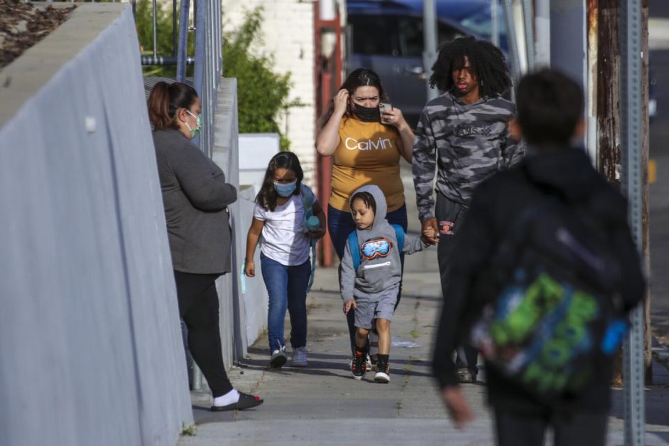 Mother and child pass by Avenue 34 site in Lincoln Heights.