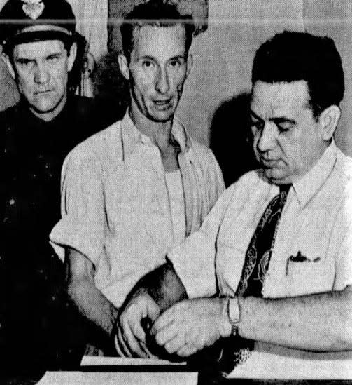 Taxi driver Hugh Dorsey Gravitt (center) is fingerprinted by Atlanta police in August 1949.