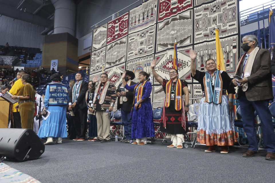 Members of the Navajo Nation Council wave to the audience after they were sworn into office Tuesday, Jan. 10, 2023 at the Bee Holdzil Fighting Scouts Event Center in Fort Defiance, Ariz. The council will have a record nine women among the 24 members. (AP Photo/Felicia Fonseca)