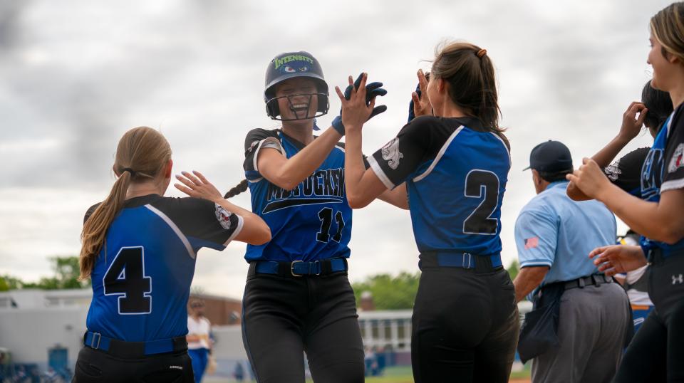 The Metuchen team celebrates a home run by Abby Kozo (11) against Spotswood on Tuesday, May 24, 2022 in the NJSIAA Sectional Group II Semi-Finals at the field at Metuchen High School.