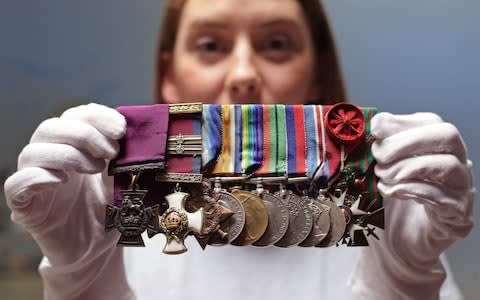 Member of staff Nancy Dillon-Malone holding up a set of medals  - Credit: Yui Mok/PA