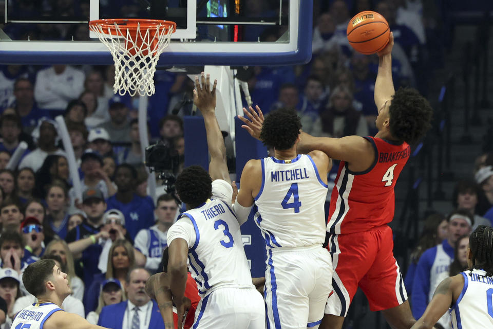 Mississippi's Jaemyn Brakefield, right, shoots while defended by Kentucky's Adou Thiero (3) and Tre Mitchell, middle, during the first half of an NCAA college basketball game Tuesday, Feb. 13, 2024, in Lexington, Ky. (AP Photo/James Crisp)