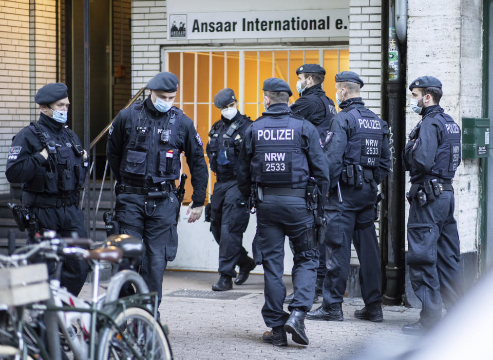 Police officers stay in front of a building of the Ansaar International association in Duesseldorf, Germany, Wednesday, May 5. 2021. The German government on Wednesday banned the Muslim organization. Buildings in 10 German states were raided, according to German news agency dpa, which said that the donations Ansaar collected were donated to welfare projects but also to groups such as Al-Nusra in Syria, the Palestinians' Hamas group and Al-Shabaab in Somalia. (Marcel Kusch/dpa via AP)