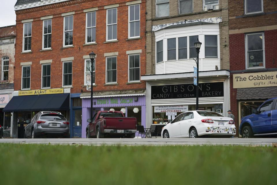 FILE - In this Nov. 22, 2017 file photo, pedestrians pass the storefront of Gibson's Food Mart & Bakery in Oberlin, Ohio. A jury has awarded $11 million to a father and son who claimed Ohio's Oberlin College and an administrator hurt their business and libeled them during a dispute that triggered protests and allegations of racism following a shoplifting incident. (AP Photo/Dake Kang, File)