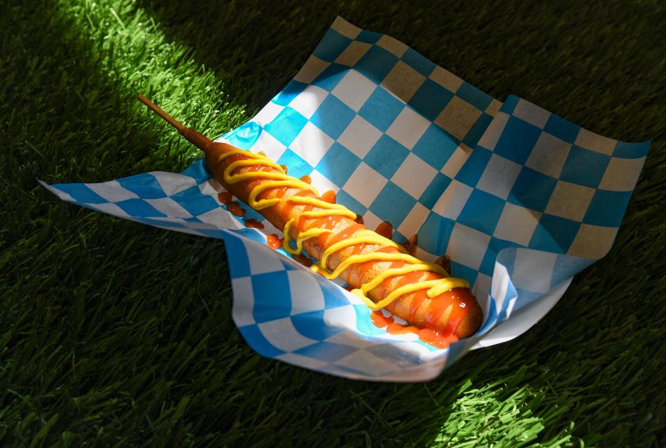 A footlong corn dog is topped with ketchup and mustard in Sioux Falls, S.D., in May 2022.