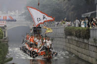Dragon boat participants from Panting village row along a canal in the historic Lychee Bay scenic area in Guangzhou in southern China's Guangdong Province, Friday, June 3, 2022. Dragon boat races returned in parts of China on Friday for the first time since the outbreak of the pandemic in late 2019, as restrictions are lifted along with a major drop in COVID-19 cases. The historic Lychee Bay scenic area in the southern Chinese manufacturing hub of Guangzhou staged races and other scaled-back celebrations to mark the holiday that commemorates the death more than 2,200 years ago of revered poet and government minister Qu Yuan. (AP Photo/Caroline Chen)