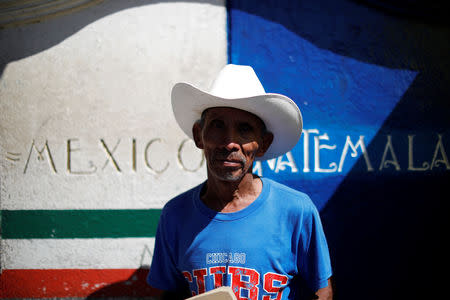 Guatemalan migrant Esteban Lorenzo poses for a picture as he waits with other Central American migrants at a bridge connecting Guatemala and Mexico to cross into Mexico, in Talisman, Mexico October 23, 2018. REUTERS/Ueslei Marcelino