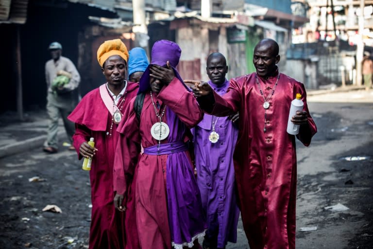 Reduced to tears: Kenyans from the Legio Maria church wince at the stench of teargas fired by police to break up angry protests on election day in Nairobi's Mathare slum