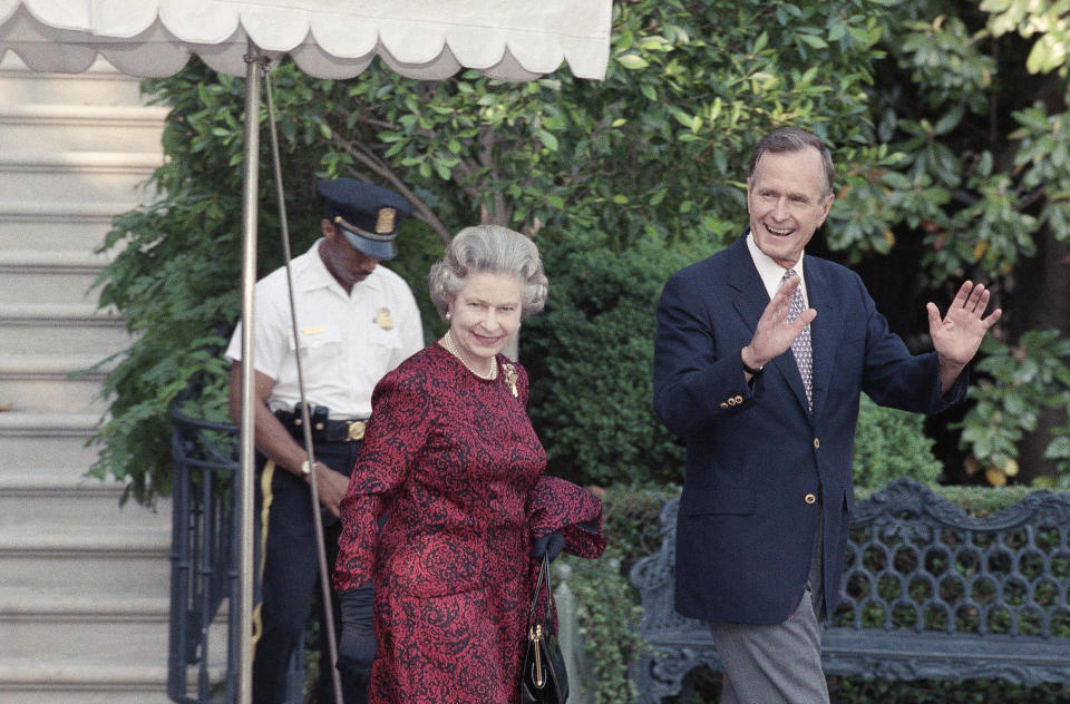 FILE - U.S. President George H.W. Bush escorts Queen Elizabeth II from the White House to a helicopter en route to Baltimore to watch her first major league baseball game, in Washington, May 15, 1991. Queen Elizabeth II, Britain's longest-reigning monarch and a rock of stability across much of a turbulent century, died Thursday, Sept. 8, 2022, after 70 years on the throne. She was 96. (AP Photo/Doug Mills, File)