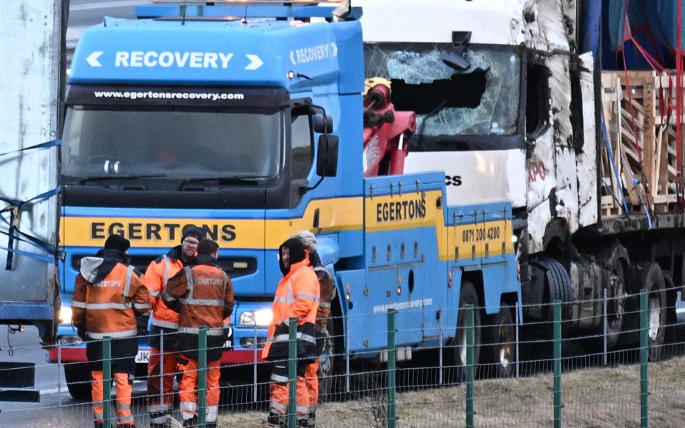 Workers recover lorries blown over on the M6 motorway during the high winds of Storm Isha, near Shap, north west England