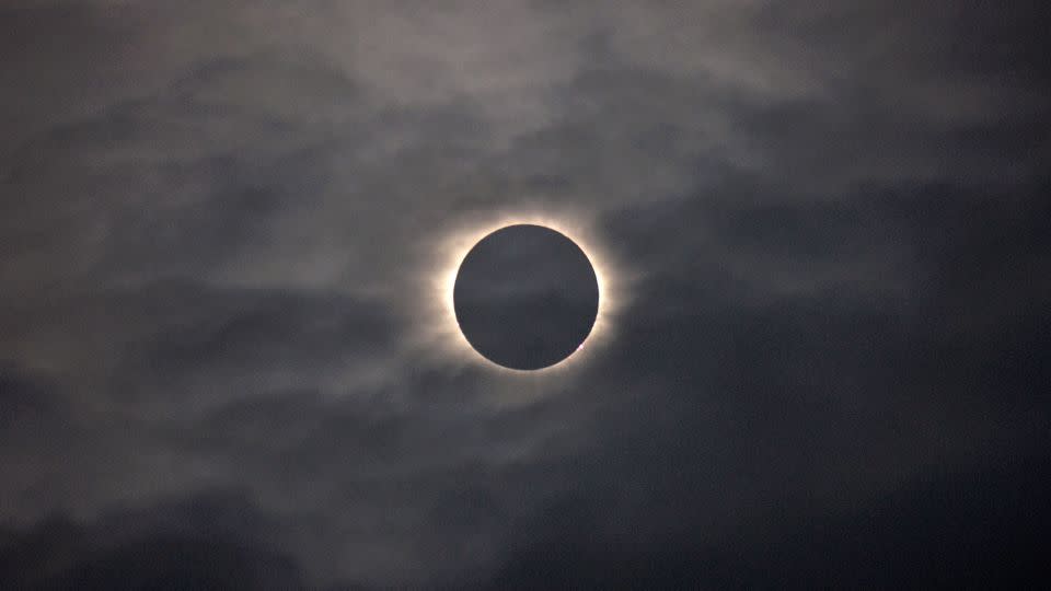 A total solar eclipse is visible through the clouds as seen from Vágar Island, one of the Faroe Islands, on March 20, 2015. - Eric Adams/AP