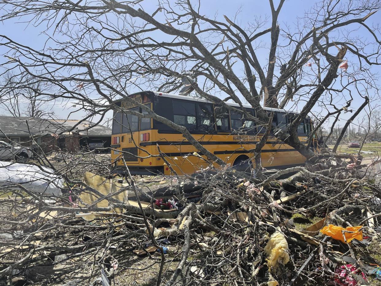 A bus passes debris on Saturday, March 25, 2023 in Silver City, Miss. Emergency officials in Mississippi say several people have been killed by tornadoes that tore through the state on Friday night, destroying buildings and knocking out power as severe weather produced hail the size of golf balls moved through several southern states. (AP Photo/Michael Goldberg)
