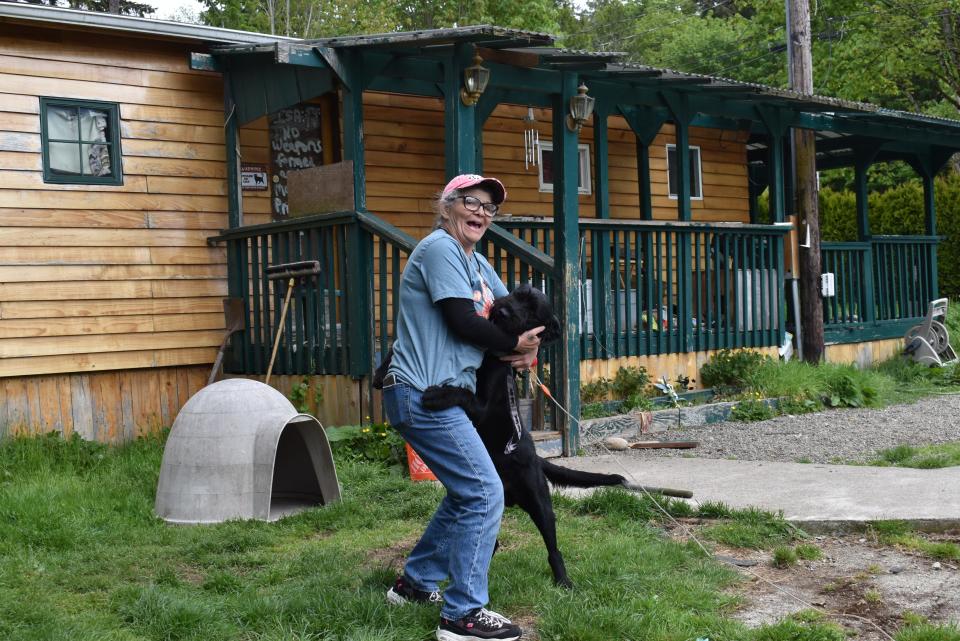 Sandy Richards plays with Stormy, her new rescue dog, in front of her mobile home in Olalla. She was homeless only a few years before coming to live in Olympic View Community since 2005, where the monthly rental rates are increasing in June. Now she's afraid of becoming homeless again.