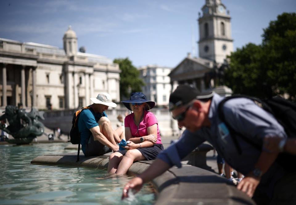 People cool off in a water fountain during a heatwave, at Trafalgar Square in London (REUTERS)