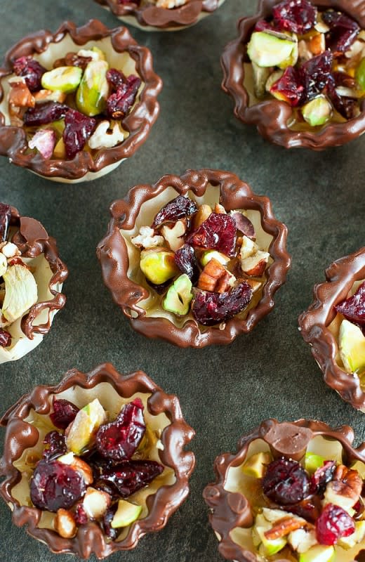 <p>Peas & Crayons</p><p>Dipped and drizzled in chocolate, these Cranberry Bliss Baklava Bites are easy to make and even easier to devour! This pint-sized, no-bake treat is perfect for the holidays! </p><p><strong>Get the recipe: <a href="https://peasandcrayons.com/2015/11/cranberry-bliss-baklava-bites.html" rel="nofollow noopener" target="_blank" data-ylk="slk:Cranberry Bliss Baklava Bites;elm:context_link;itc:0;sec:content-canvas" class="link rapid-noclick-resp">Cranberry Bliss Baklava Bites</a></strong></p>