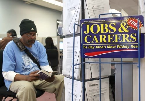 A job seeker waits to use a phone at a career center in Richmond, Calif. Economist Jack Kyser predicts that the state's jobless rate will average 12.6% next year, but other economists call his prediction overly pessimistic.