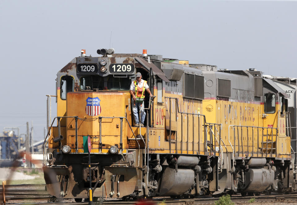 FILE - In this July 20, 2017, file photo, a Union Pacific Railroad Company employee stands on a locomotive in Council Bluffs, Iowa. More than two dozen major companies ranging from Campbell Soup to Kia filed anti-trust lawsuits on Sept. 30, 2019 against the nation's four largest railway companies, contending the railroads had a price-fixing scheme to illegally boost profits. (AP Photo/Nati Harnik, File)