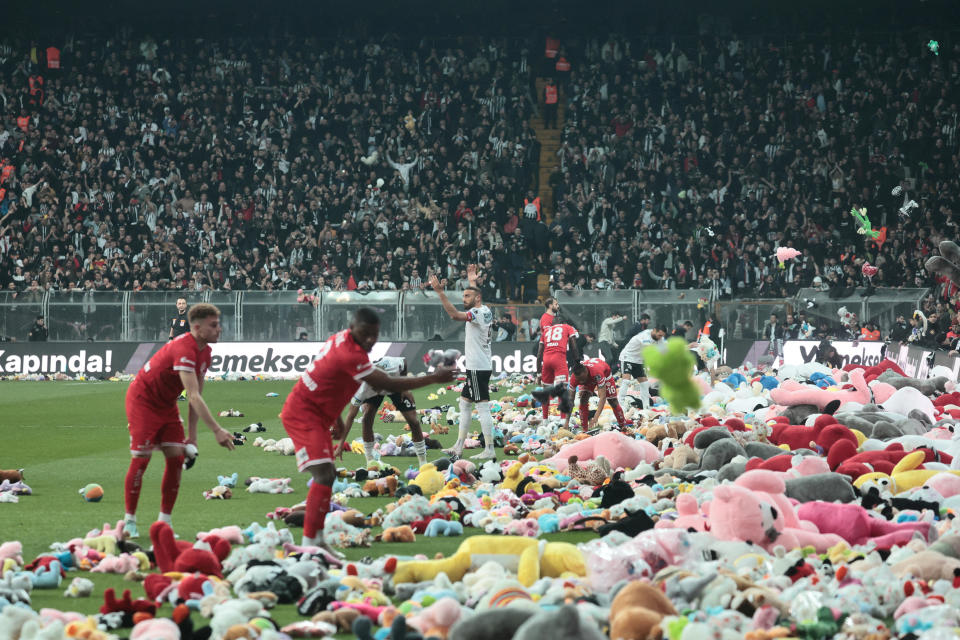 Besiktas' Cenk Tosun reacts as fans throw toys on the pitch for children affected by earthquake during a Turkish Super League match between Besiktas and Antalyaspor at Vodafone Park in Istanbul, Turkey on Sunday.  / Credit: STRINGER / REUTERS