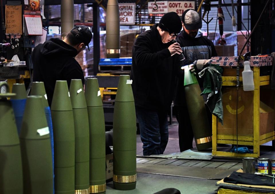 A shell inspector uses a flashlight to look for flaws inside the cylinders before the nose of the shell is added in Scranton, Pennsylvania on Feb. 01, 2023. Each shell is inspected at least 14 times during the production process. Production of 155mm shells (projectile bombs) at the Scranton Army Ammunition Plant has been steady as the U.S. commitment to the war in Ukraine ramps up. (Michael S. Williamson/The Washington Post via Getty Images)