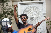 <p>Isaiah Wallace plays his guitar standing on the base that formerly supported a Confederate soldier statue after a group of protesters pulled it down during a rally Monday, Aug. 14, 2017, in Durham, N.C. (Photo: Casey Toth/The Herald-Sun via AP) </p>