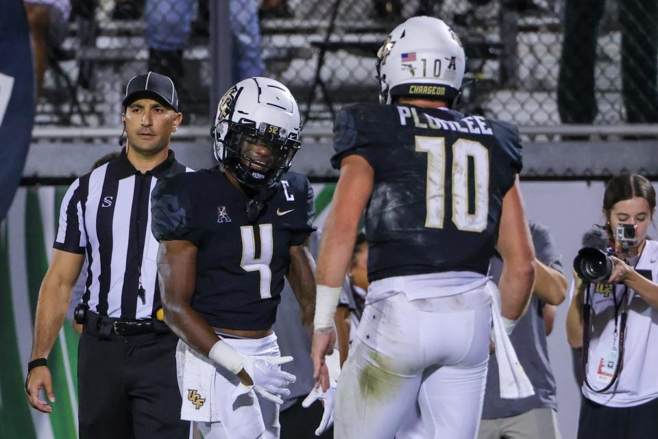 Oct 5, 2022; Orlando, Florida, USA; UCF Knights wide receiver Ryan O'Keefe (4) celebrates with quarterback John Rhys Plumlee (10) after scoring during the second half against the Southern Methodist Mustangs at FBC Mortgage Stadium. Mandatory Credit: Mike Watters-USA TODAY Sports