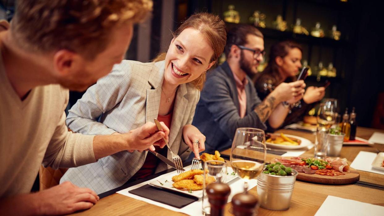 Une jeune femme au restaurant avec des amis