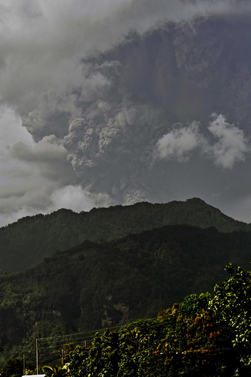 Plumes of ash rise from the La Soufriere volcano as it erupts on the eastern Caribbean island of St. Vincent, as seen from Chateaubelair, Friday, April 9, 2021. (AP Photo/Orvil Samuel)