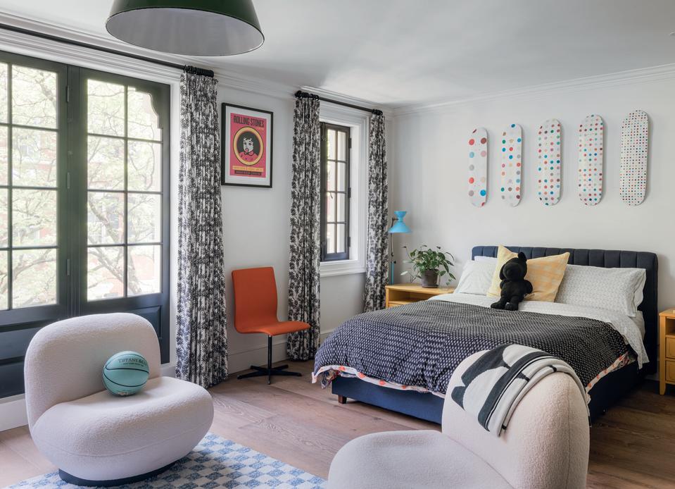 A bedroom with a artworks on the wall and seating area