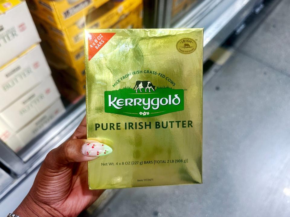 The writer holds a hold package with green Kerrygold logo on it and black letters spelling out "pure Irish butter"