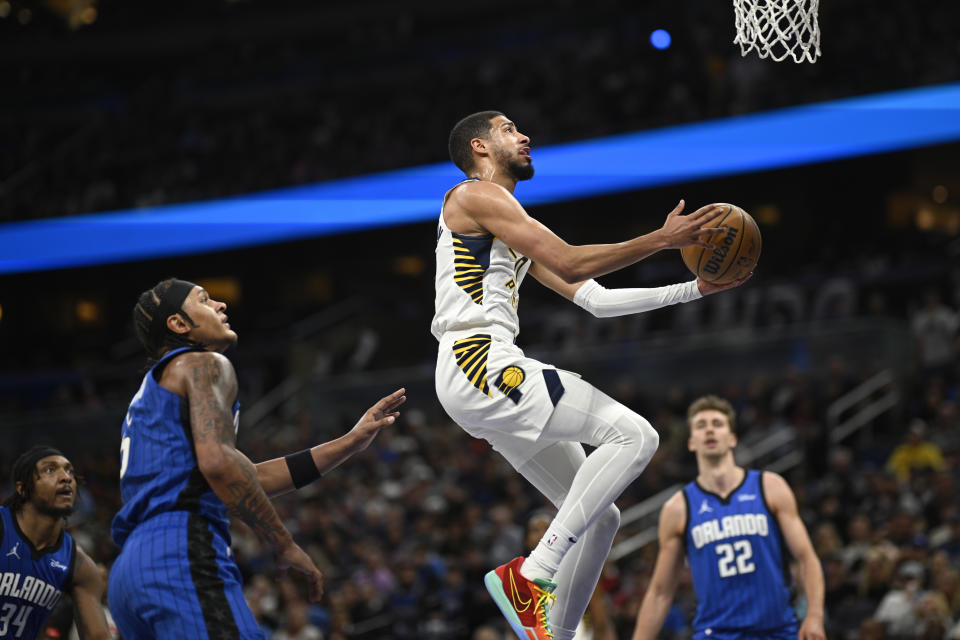 Indiana Pacers guard Tyrese Haliburton goes up for a shot as Orlando Magic center Wendell Carter Jr. (34), forward Paolo Banchero, second from left, and forward Franz Wagner (22) look on during the first half of an NBA basketball game, Sunday, March 10, 2024, in Orlando, Fla. (AP Photo/Phelan M. Ebenhack)
