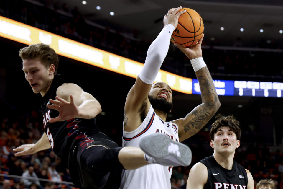 Auburn forward Johni Broome (4) is fouled by Penn guard Andrew Laczkowskil, left, during the second half of an NCAA college basketball game Tuesday, Jan. 2, 2024, in Auburn, Ala. (AP Photo/Butch Dill)