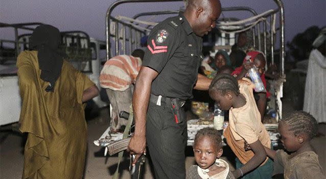 A Nigerian police officer helps children who were rescued by Nigerian soldiers from Boko Haram extremists at Sambisa Forest to get off a truck upon their arrival at a refugee camp in Yola, Nigeria Photo: AP/Sunday Alamba