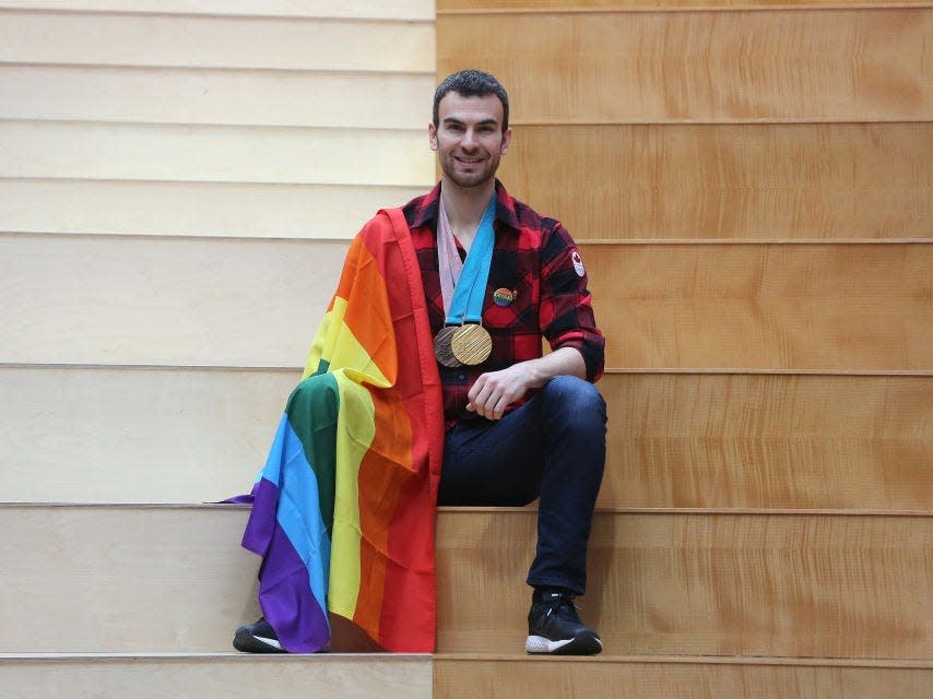 Eric Radford with his Olympic medals and a pride flag