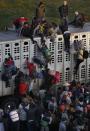 Los migrantes centroamericanos, que forman parte de la caravana que espera llegar a la frontera con Estados Unidos, se suben a un camión de pollos en Irapuato, México, el lunes 12 de noviembre de 2018. (AP Foto / Marco Ugarte)