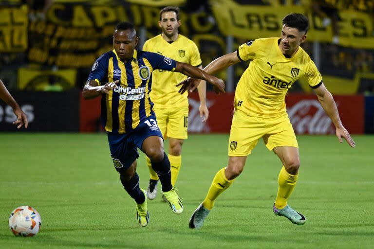 El colombiano Jaminton Campaz deja en el camino al uruguayo Maximiliano Silvera durante el partido entre Rosario Central y Peñarol, de Uruguay, por la Copa Libertadores