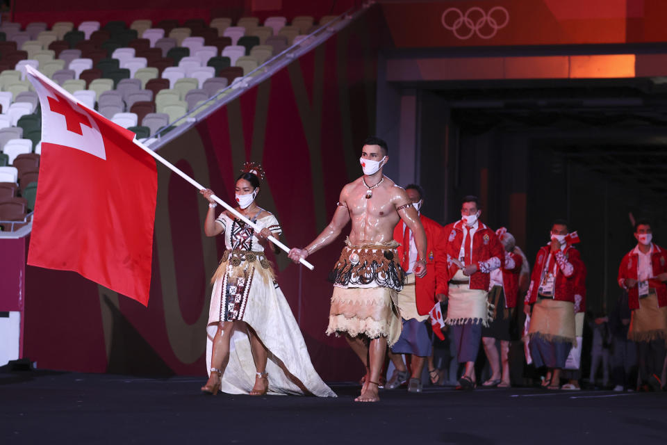 TOKYO, JAPAN - JULY 23: Flag bearers Malia Paseka and Pita Taufatofua of Team Tonga lead their team out during the Opening Ceremony of the Tokyo 2020 Olympic Games at Olympic Stadium on July 23, 2021 in Tokyo, Japan. (Photo by Jamie Squire/Getty Images)