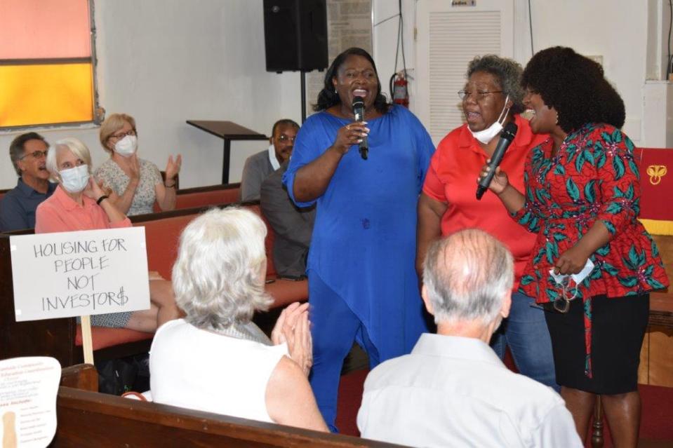 Lena Gillis, Lynn Rivers, and Gainesville City Commissioner Duncan-Walker lead the audience in a re-purposed gospel song at Shady Grove Primitive Baptist Church, where residents gathered Aug. 3 to oppose the city's elimination of single-family zoning.