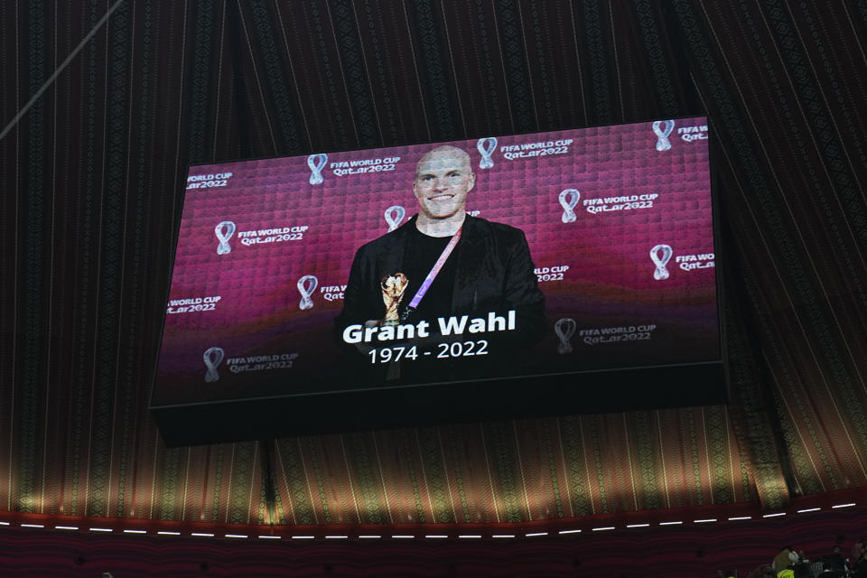 FILE - A tribute to journalist Grant Wahl is shown on a screen before the World Cup quarterfinal soccer match between England and France, at the Al Bayt Stadium in Al Khor, Qatar, Saturday, Dec. 10, 2022. On Friday, Dec. 16, The Associated Press reported on stories circulating online incorrectly claiming Wahl, who died in Qatar last week, was killed by the COVID-19 vaccine.(AP Photo/Abbie Parr, File)