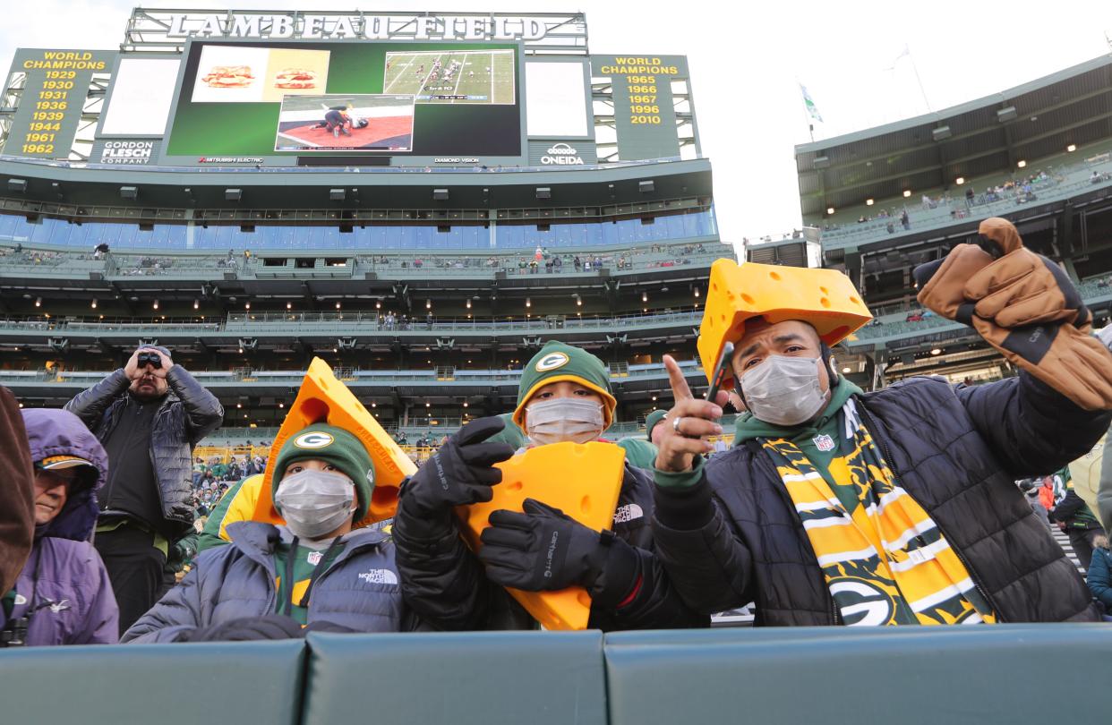 Packers fans don masks before their game at Lambeau Field in Green Bay on Sunday, Nov. 28, 2021.