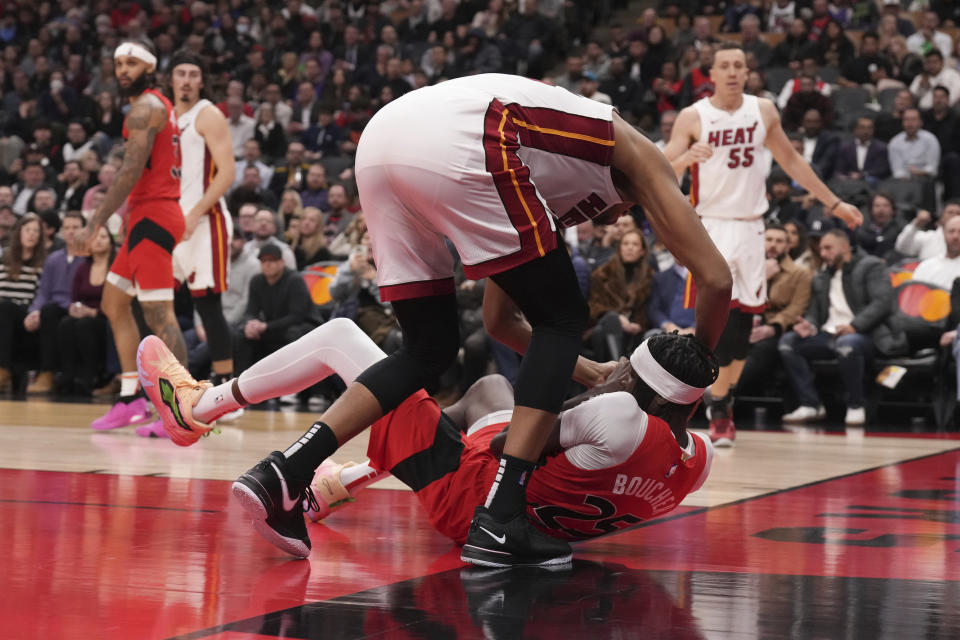 Toronto Raptors' Chris Boucher, bottom, tries to protect the ball from Miami Heat's Orlando Robinson during the second half of an NBA basketball game, Wednesday, Dec. 6, 2023 in Toronto. (Chris Young/The Canadian Press via AP)