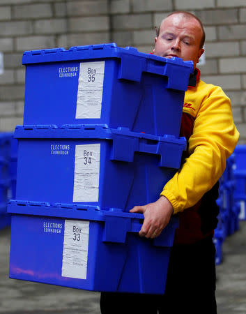FILE PHOTO: An Edinburgh City Council contractor carries boxes of postal ballots in a storage warehouse in Edinburgh, Scotland May 5, 2010. REUTERS/David Moir/File Photo