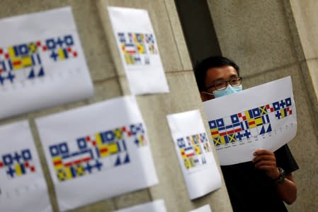 A man holds a poster during a protest outside the British Consulate-general office in Hong Kong