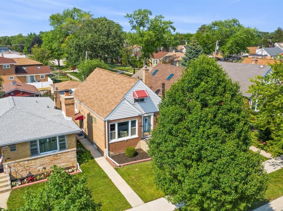 an aerial view of a neighborhood with the house for sale near chicago in the middle on a tree lined street