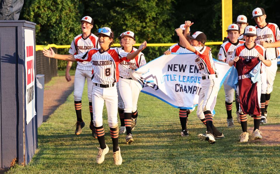 Middleboro 12U Nationals players celebrate with the New England banner at the conclusion of their game against Bangor (Maine) East at the A. Bartlett Giamatti Little League Leadership Training Center in Bristol, Connecticut, for the Little League New England Regional Tournament on Thursday, Aug. 11, 2022.