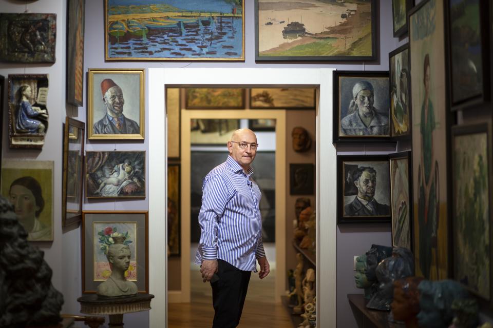 In this photo taken on Friday, March 15, 2019, Russian art collector Roman Babichev arrives to an interview with The Associated Press in his apartment in Moscow, Russia. Babichev has tracked down and collected many works by Russia's forgotten modernist painters. (AP Photo/Alexander Zemlianichenko)