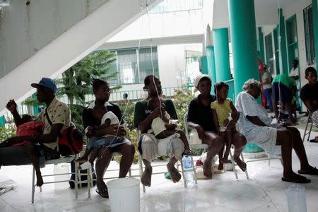 Adults hold children receiving treatment for cholera after Hurricane Matthew in the Hospital of Port-a-Piment, Haiti, October 9, 2016. REUTERS/Andres Martinez Casares