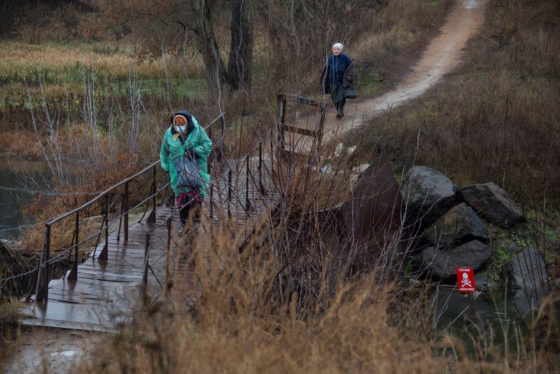 FILE PHOTO: Women walk in the village of Staromarivka