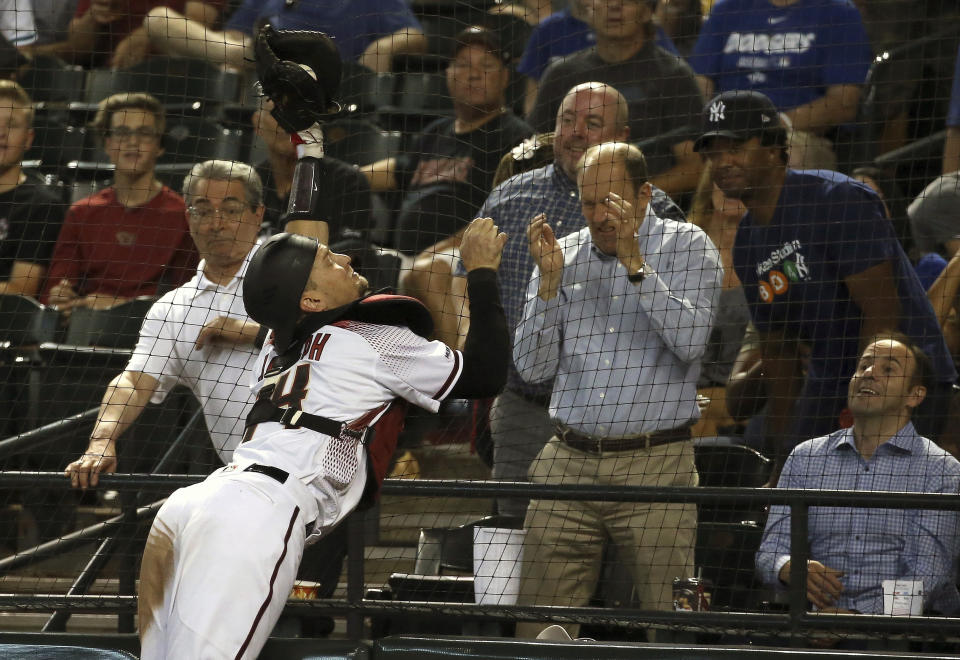 Arizona Diamondbacks catcher Caleb Joseph dives into the netting to make a catch on a foul ball hit by Los Angeles Dodgers' Enrique Hernandez during the fourth inning of a baseball game Wednesday, June 26, 2019, in Phoenix. (AP Photo/Ross D. Franklin)